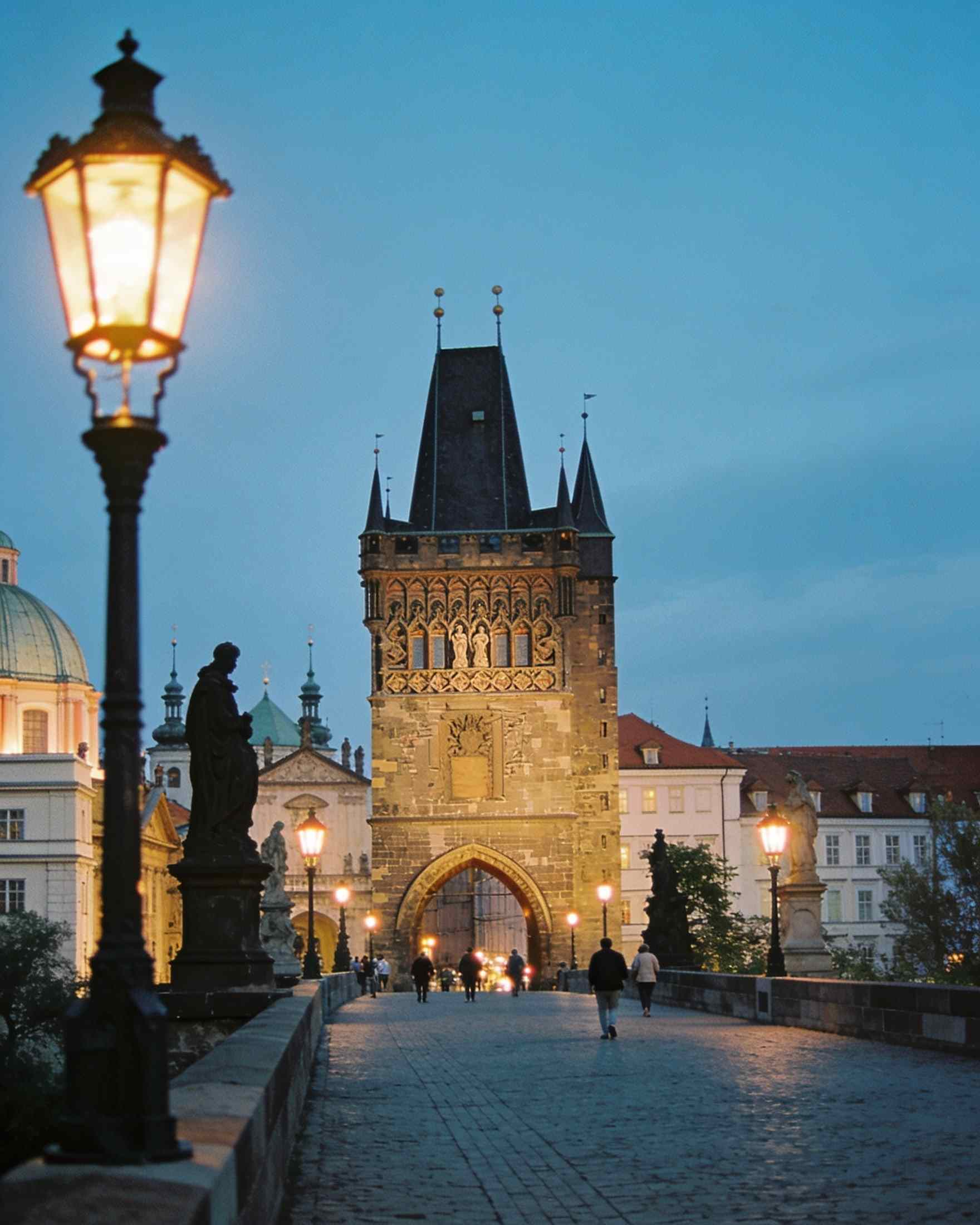 The Gothic Old Town Bridge Tower at the end of Charles Bridge at blue hour, the street lamps lit